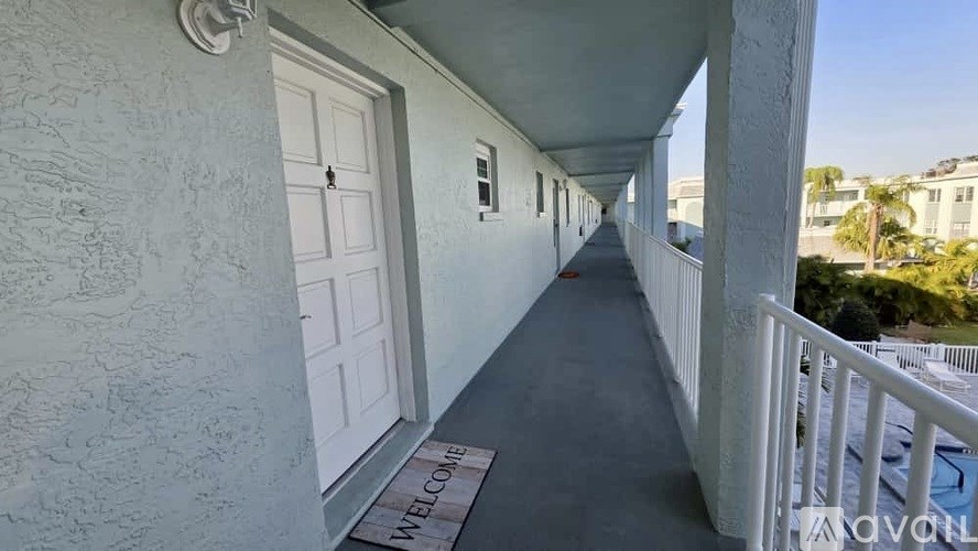 A balcony with a "Welcome" doormat and a view of the outside.