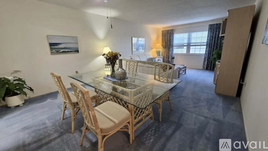 A dining room with a glass table and chairs.