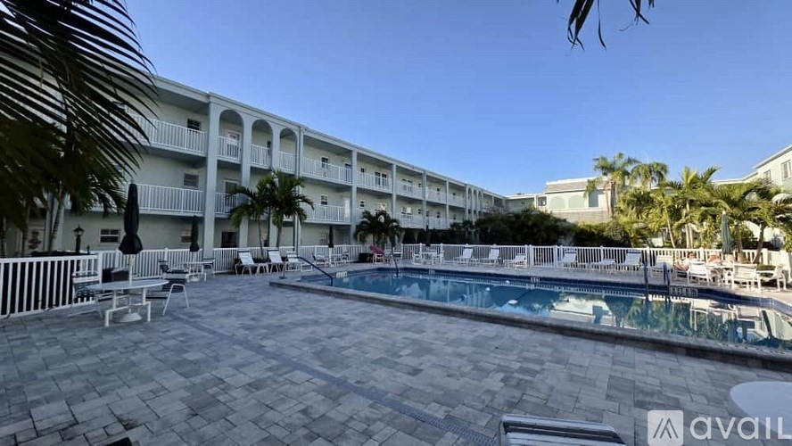 A pool area with a building in the background and a sign that says "available".