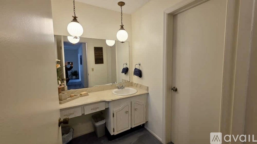 A bathroom with a sink, mirror, and light fixture.