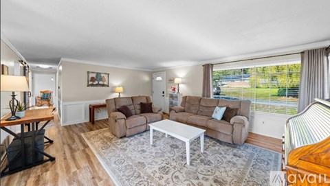 A living room with a white coffee table and brown couches.