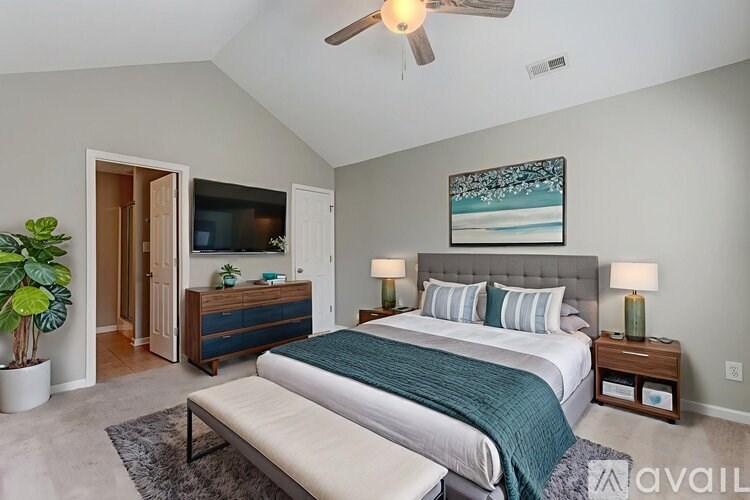A bedroom with a bed, a bench, and a ceiling fan.