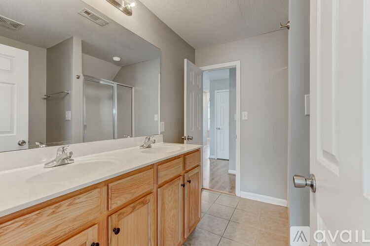 A bathroom with a double sink vanity and a large mirror.