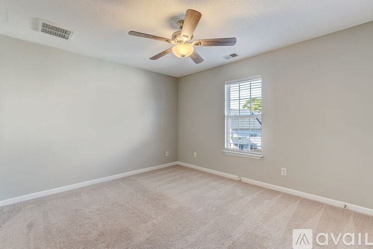 A room with a ceiling fan and a window.