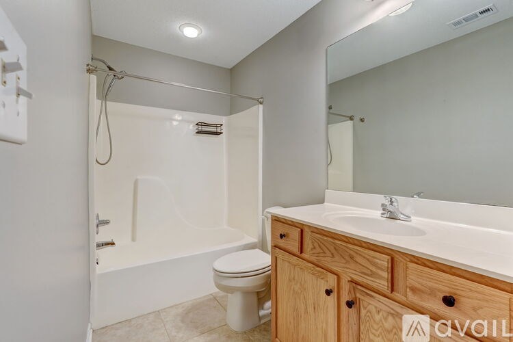 A bathroom with a white tub, sink, and toilet.