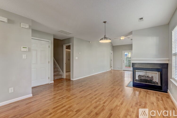 A living room with a fireplace and a wooden floor.