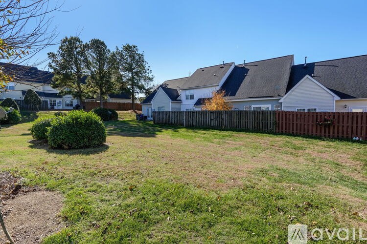 A sunny day in a residential area with houses and a fence.