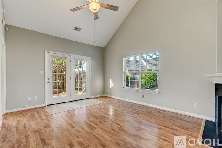 A room with a ceiling fan and a window with blinds.
