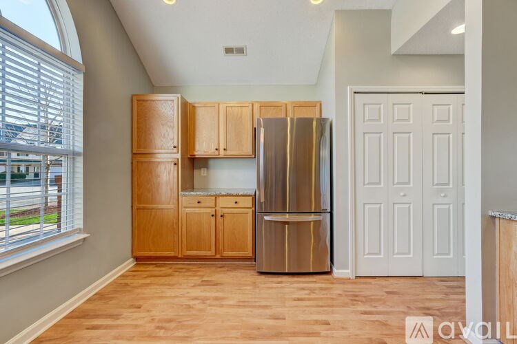 A kitchen with wooden cabinets and a stainless steel refrigerator.