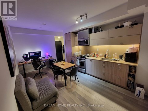 A modern kitchen and living room area with a dining table and chairs.