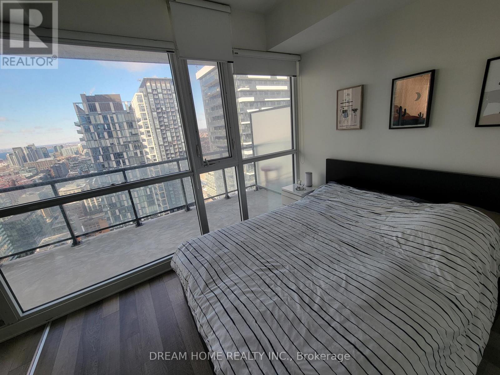 A bedroom with a large bed and a view of the city.