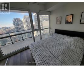 A bedroom with a large bed and a view of the city.