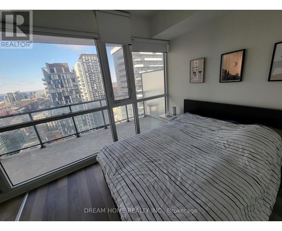 A bedroom with a large bed and a view of the city.