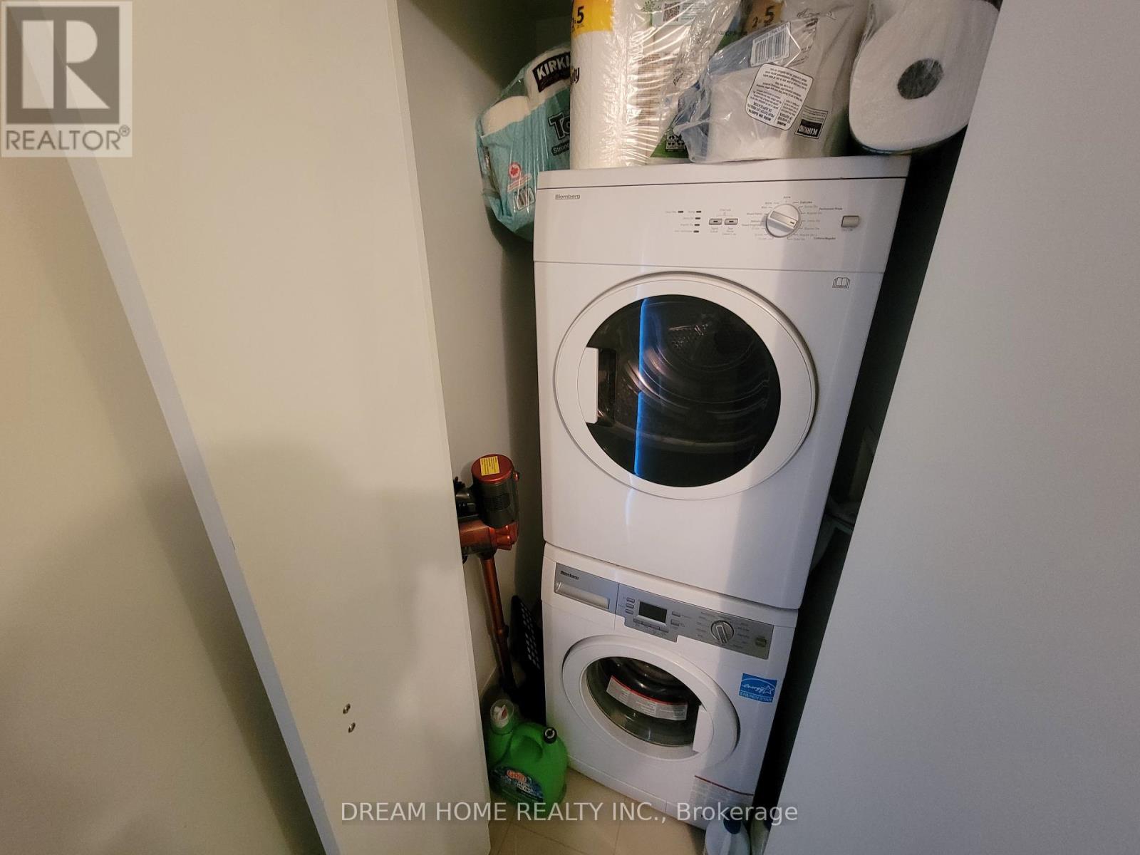 A white washing machine is in a small space with other items.