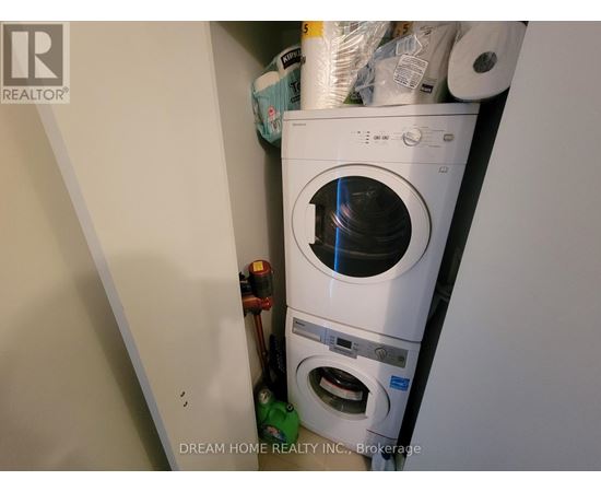 A white washing machine is in a small space with other items.