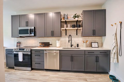 A kitchen with dark brown cabinets and a black oven.