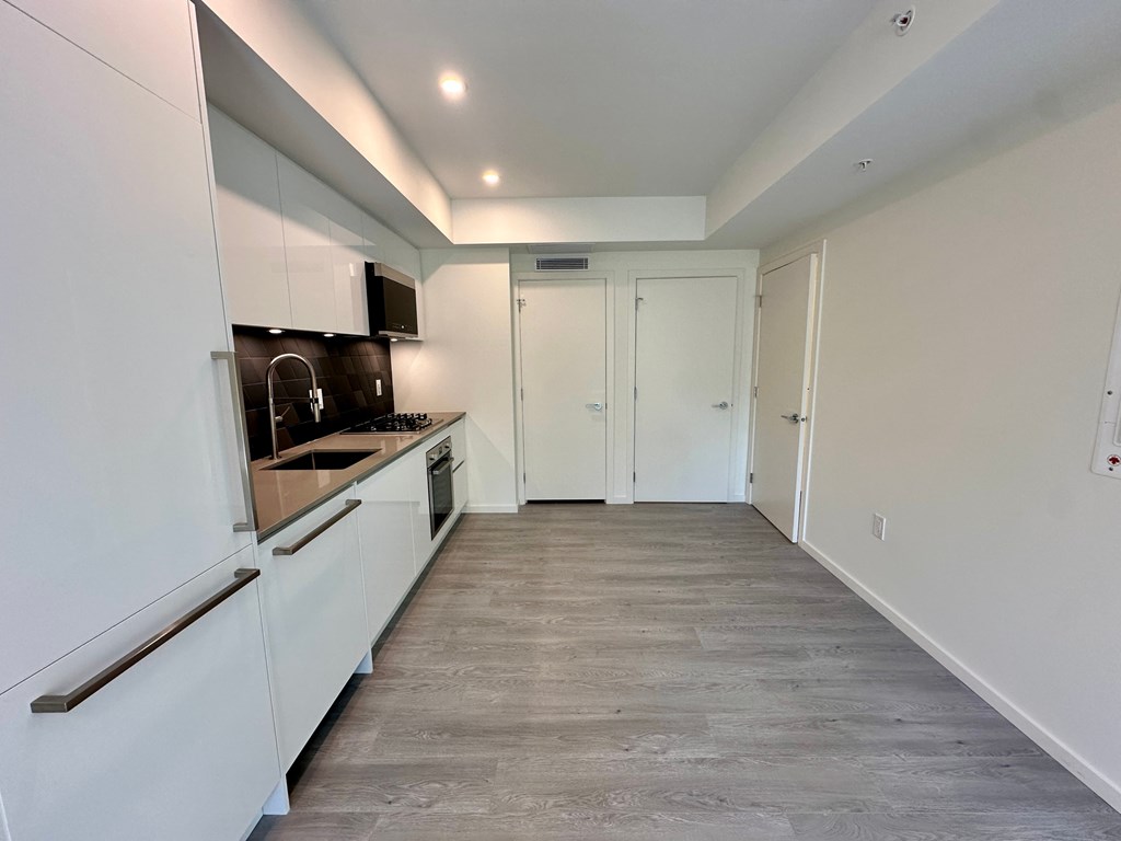 A kitchen with white cabinets and a black countertop.