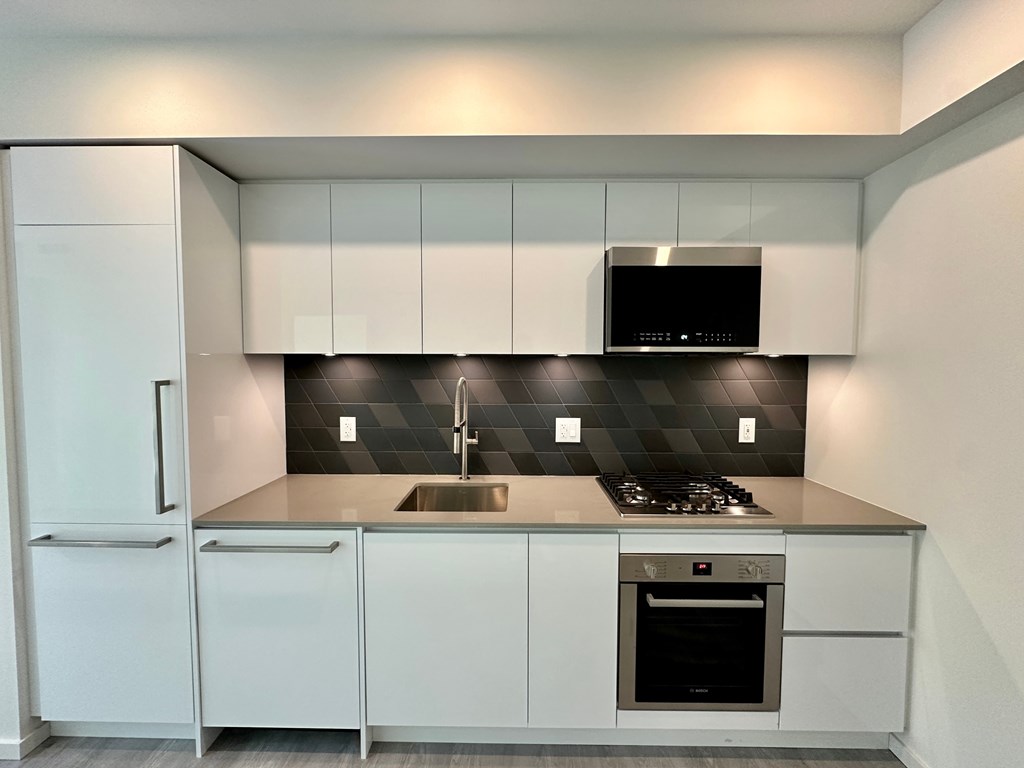 A modern kitchen with a black and white checkered backsplash.