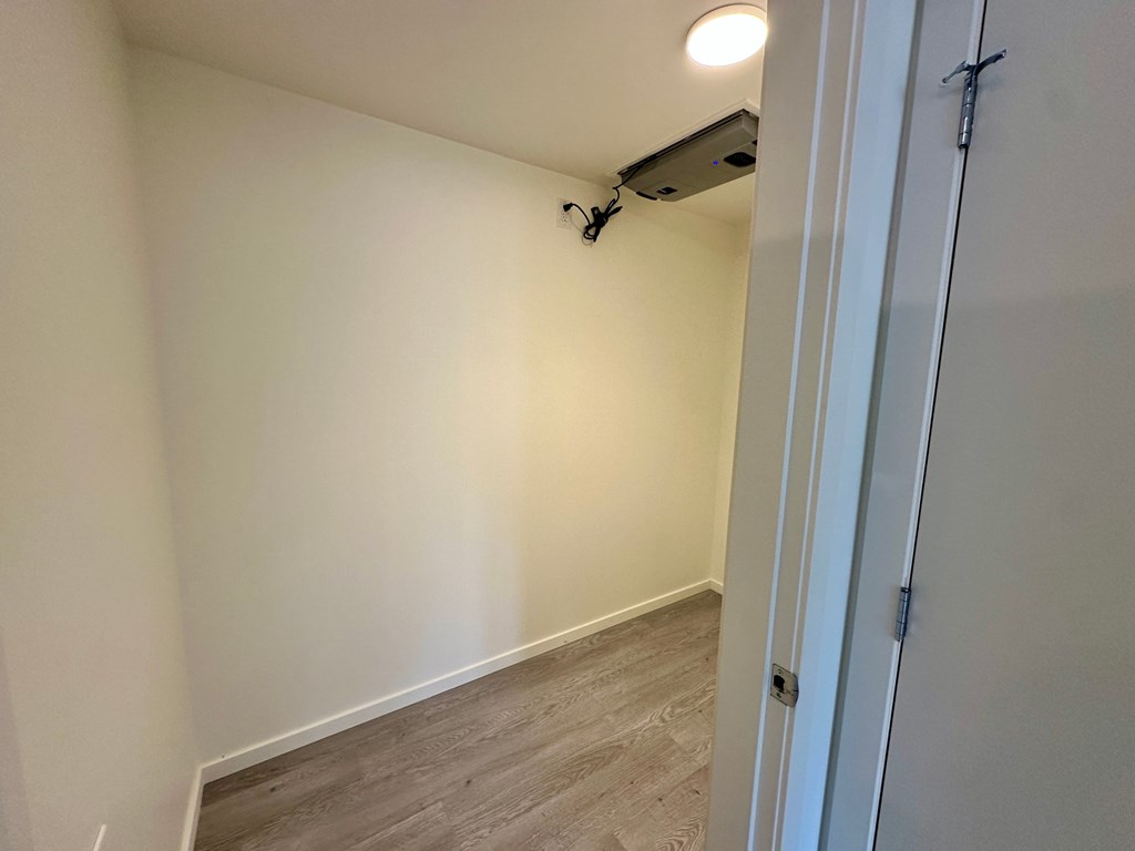 A room with a white door and a security camera mounted on the wall.