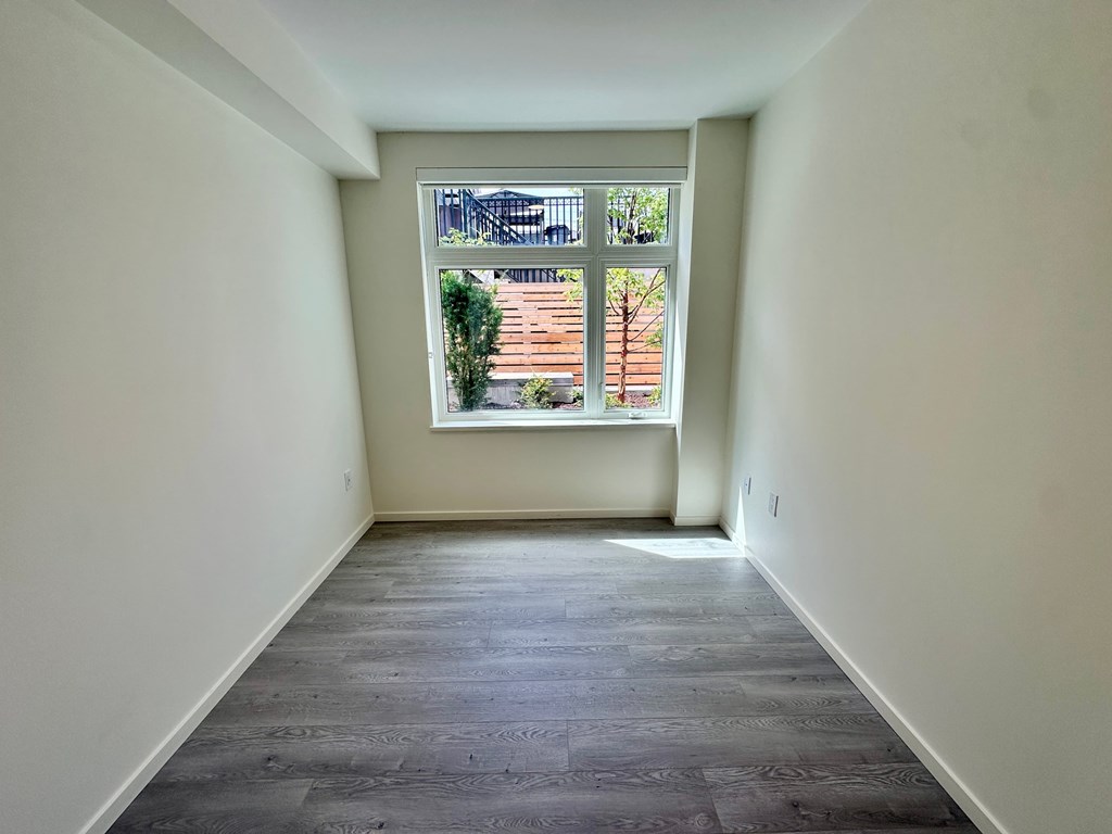 A room with a window overlooking a wooden deck.