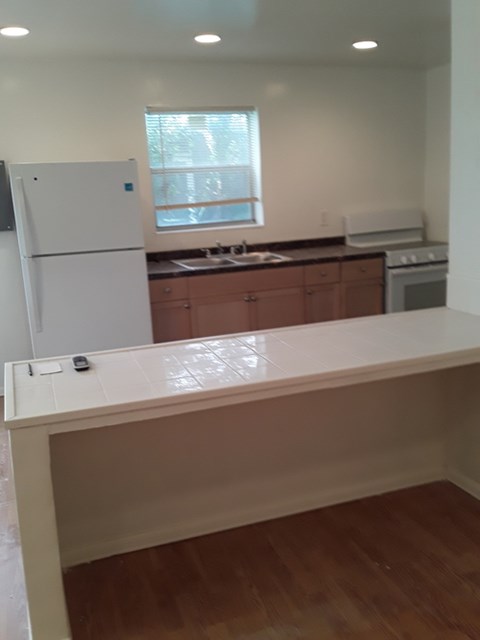 A kitchen with a white fridge and wooden cabinets.