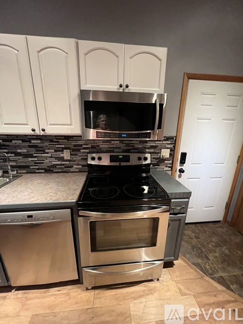 A kitchen with a stove top oven and a microwave above it.