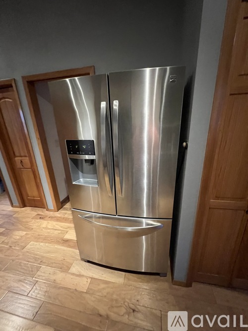 A stainless steel refrigerator with a water and ice dispenser in the middle.