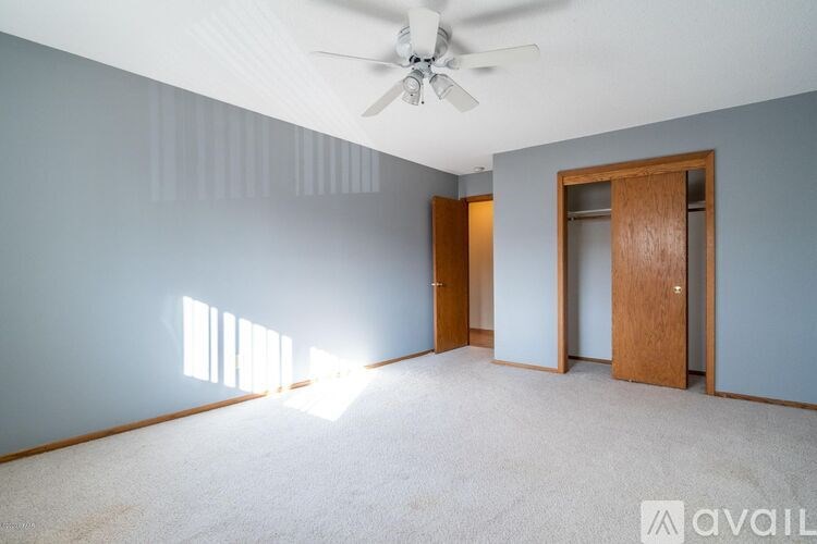 A room with a ceiling fan and two doors.