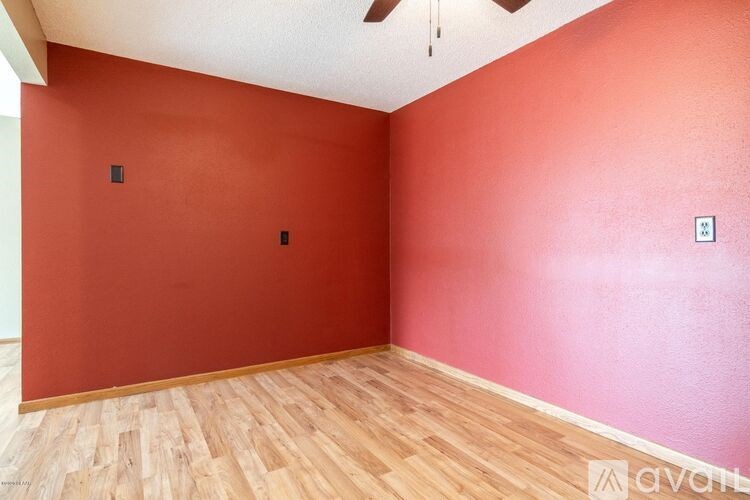 A room with red walls and wooden flooring.