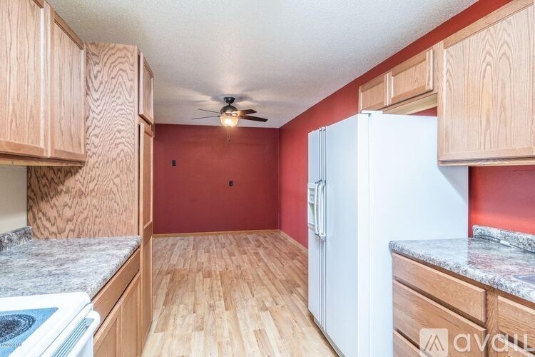 A kitchen with wooden cabinets and a white refrigerator.