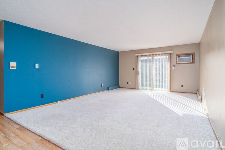 A room with a blue wall and a white rug.