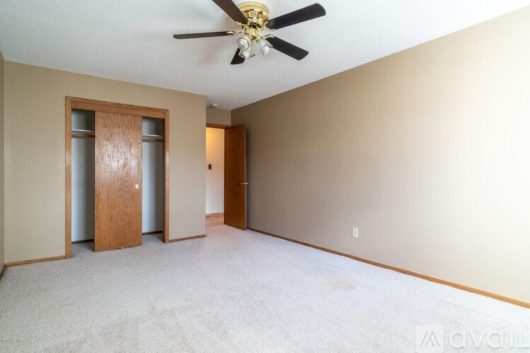 A room with a ceiling fan and two doors.