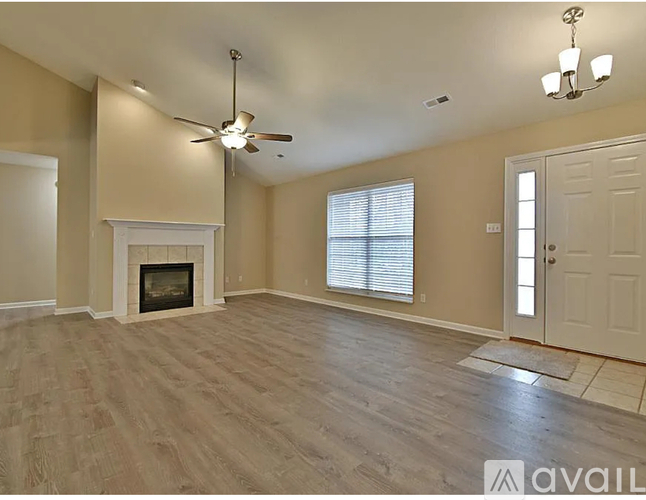 A living room with a fireplace and a ceiling fan.