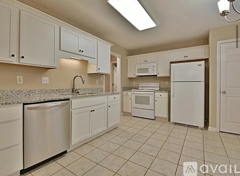 A kitchen with white appliances and cabinets.