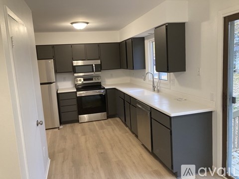 A kitchen with black cabinets and stainless steel appliances.