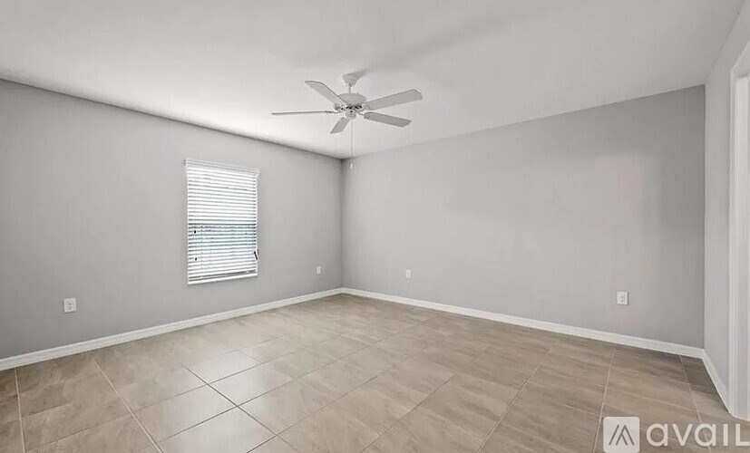 A room with a ceiling fan and a window with blinds.