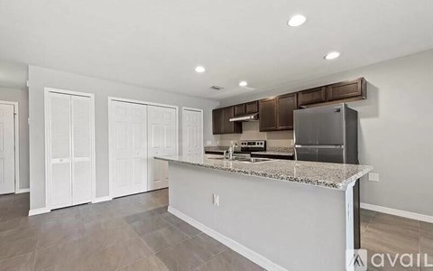 A kitchen with white cabinets and a marble countertop.
