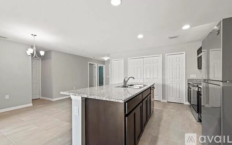 A kitchen with a granite countertop and a refrigerator.