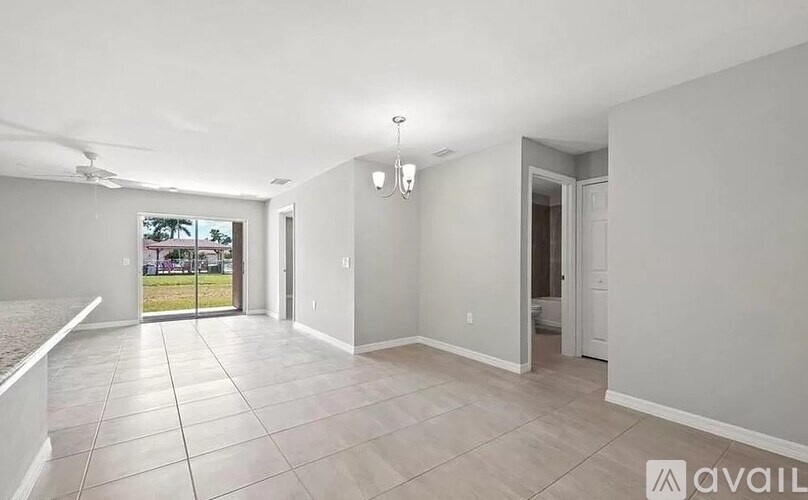 A spacious room with tiled flooring and a ceiling fan.