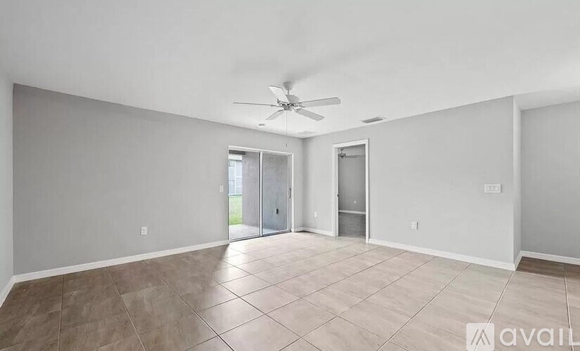 A spacious room with a ceiling fan and tiled flooring.
