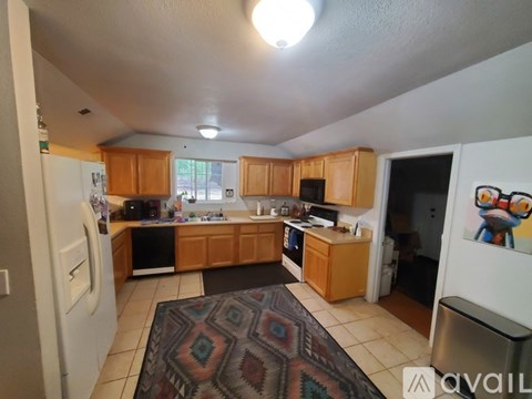 A kitchen with wooden cabinets and a rug on the floor.