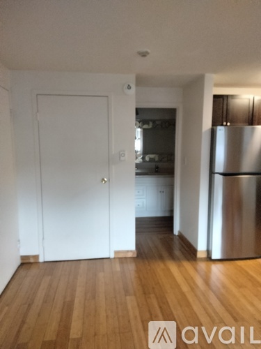 A kitchen with wooden floors and a striped curtain.