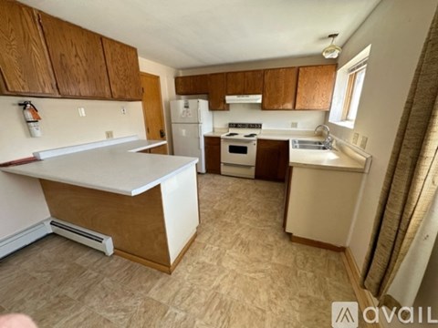 A kitchen with wooden cabinets and a white refrigerator.