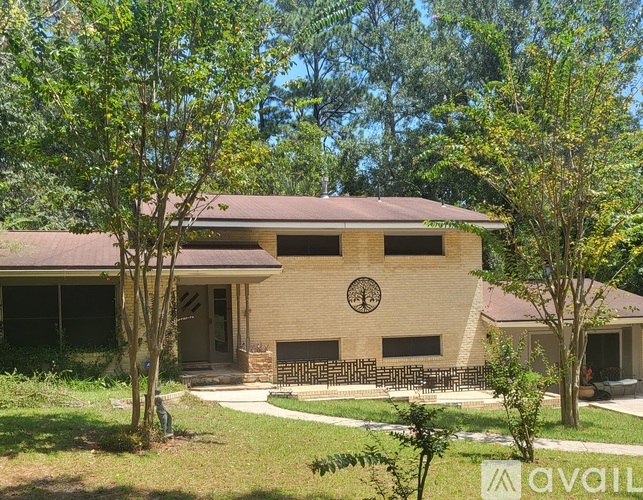 A house with a clock on the wall and a bench outside.
