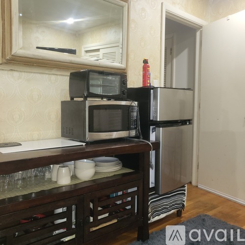 A kitchen with a microwave, oven, and refrigerator.