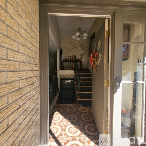A hallway with a brick wall and a carpeted floor.