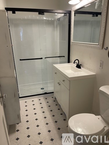 A bathroom with a toilet, sink, and shower.
