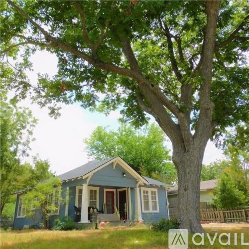 A blue house with a tree in front of it.