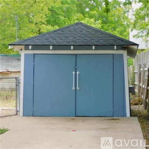 A blue garage door with a black roof.