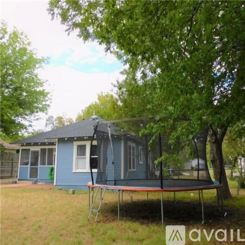 A blue house with a trampoline in front.